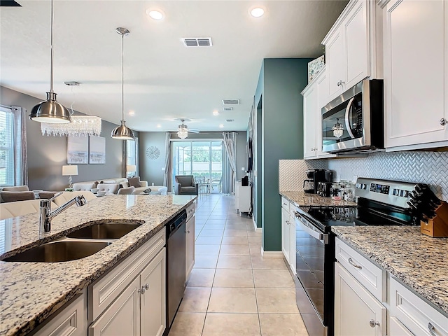 kitchen featuring sink, appliances with stainless steel finishes, hanging light fixtures, backsplash, and white cabinets