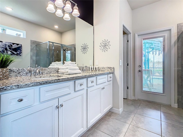 bathroom featuring vanity, a shower with shower door, tile patterned floors, and an inviting chandelier