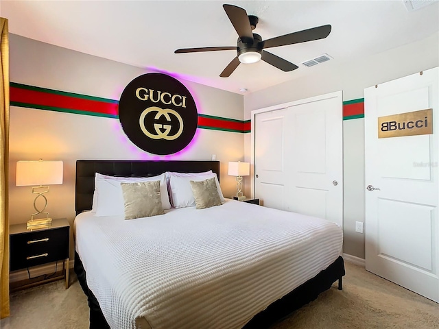 bedroom with light colored carpet, ceiling fan, and a closet