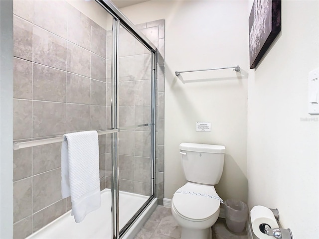 bathroom with a shower with door and toilet