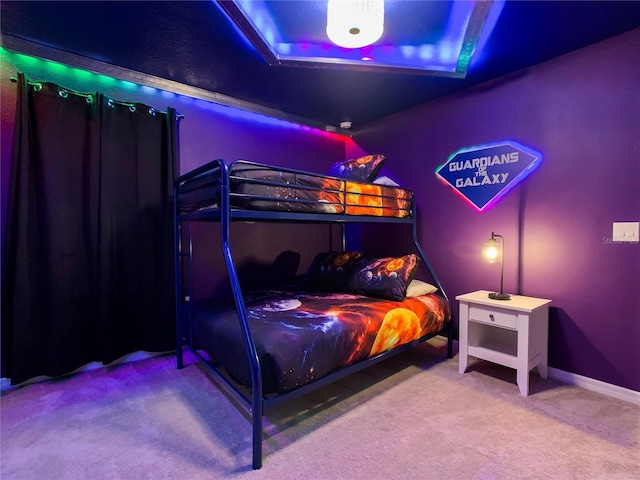 bedroom featuring a tray ceiling and carpet flooring