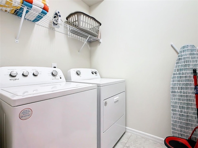 washroom with washing machine and dryer and light tile patterned floors