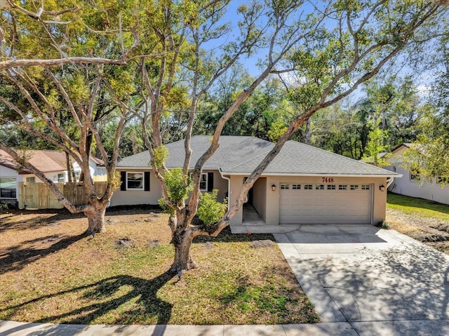 ranch-style house featuring a garage, concrete driveway, fence, and stucco siding