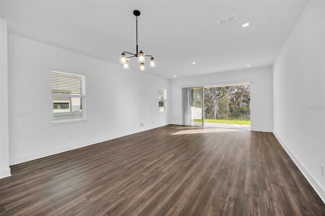 unfurnished living room with dark hardwood / wood-style floors and a chandelier