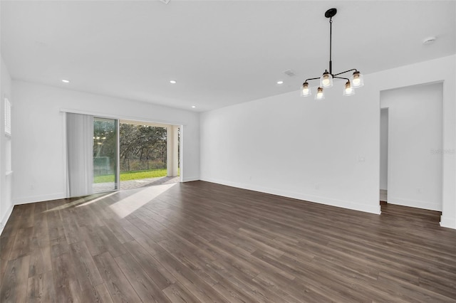 unfurnished living room featuring dark hardwood / wood-style flooring and a chandelier