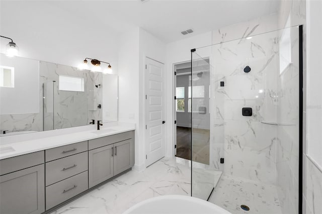 bathroom with vanity, independent shower and bath, and a wealth of natural light