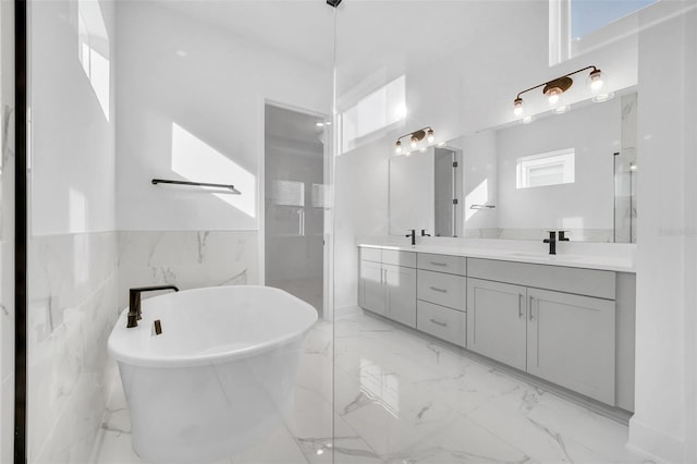 bathroom featuring vanity, a bathtub, and tile walls