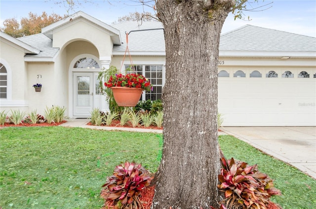 doorway to property featuring a garage and a yard