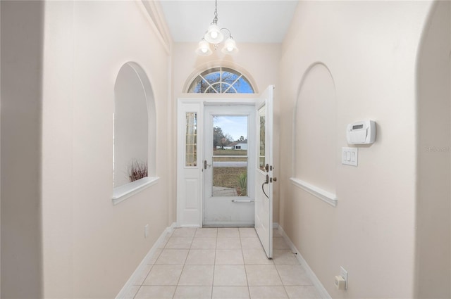 tiled foyer entrance featuring an inviting chandelier