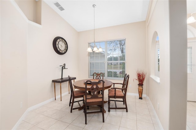 dining room with light tile patterned flooring, lofted ceiling, and an inviting chandelier