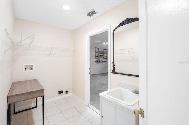 washroom with sink, hookup for a washing machine, and light tile patterned floors
