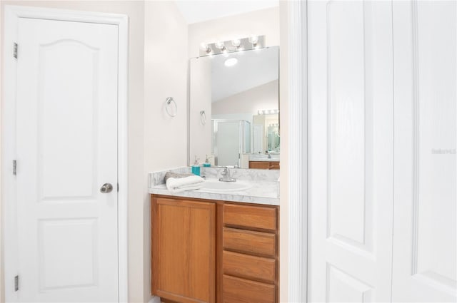 bathroom with vanity, an enclosed shower, and vaulted ceiling
