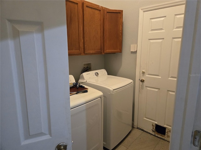 clothes washing area with cabinet space, light tile patterned flooring, and independent washer and dryer