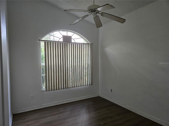 spare room featuring dark wood-style floors, baseboards, and a ceiling fan