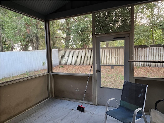 unfurnished sunroom with a healthy amount of sunlight and vaulted ceiling