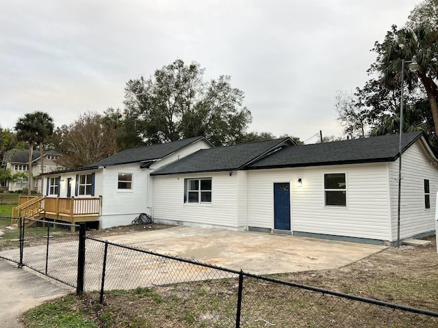 back of property featuring a wooden deck and a patio area