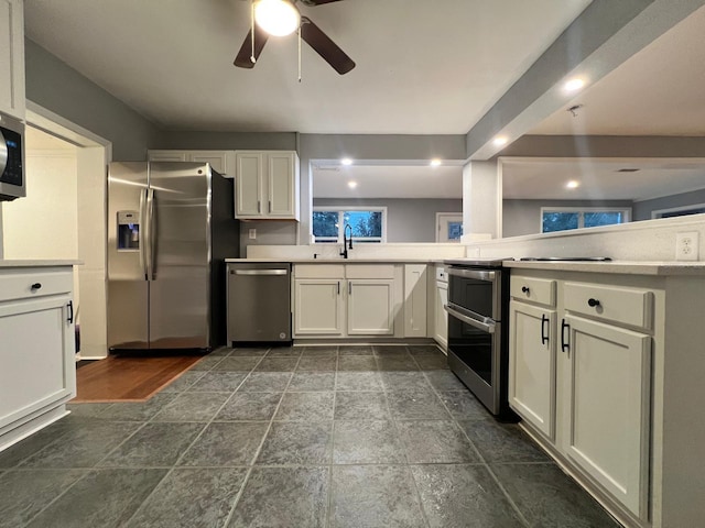 kitchen featuring white cabinetry, ceiling fan, appliances with stainless steel finishes, and sink