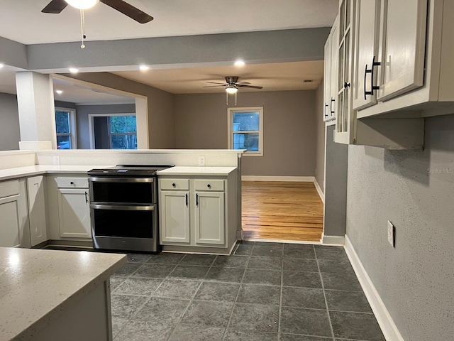 kitchen with ceiling fan, double oven range, and kitchen peninsula