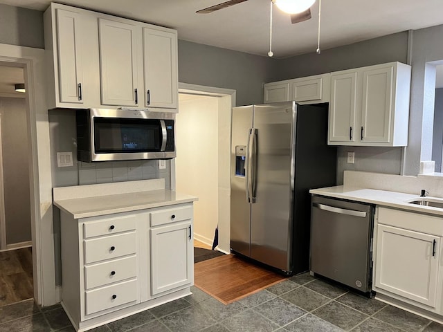 kitchen with appliances with stainless steel finishes, tasteful backsplash, white cabinetry, dark hardwood / wood-style flooring, and ceiling fan