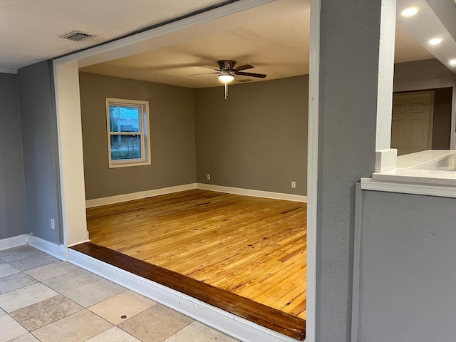 tiled spare room featuring ceiling fan