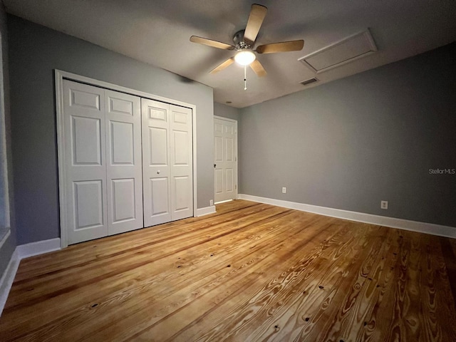 unfurnished bedroom featuring wood-type flooring, a closet, and ceiling fan