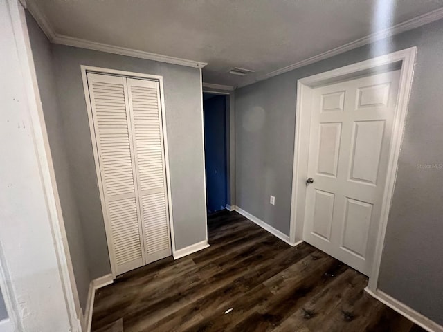 unfurnished bedroom with ornamental molding, dark hardwood / wood-style floors, and a closet