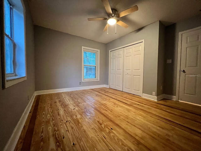 unfurnished bedroom with ceiling fan, a closet, and light hardwood / wood-style flooring