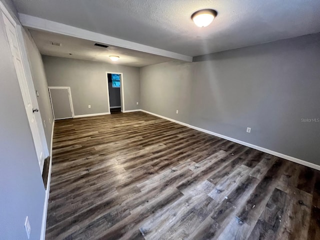 empty room featuring dark hardwood / wood-style floors and a textured ceiling