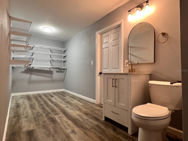 bathroom with hardwood / wood-style flooring, vanity, and toilet