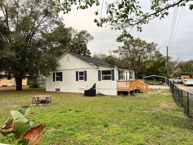 rear view of property featuring a deck and a lawn