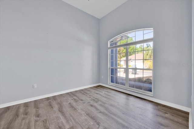 empty room featuring baseboards and wood finished floors