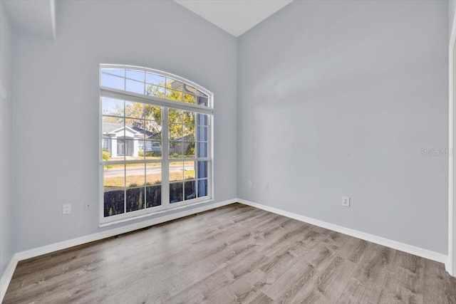 unfurnished room with baseboards and wood finished floors