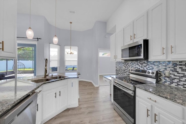 kitchen featuring tasteful backsplash, visible vents, stainless steel appliances, and a sink