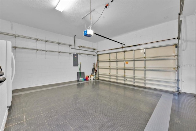 garage with concrete block wall, electric panel, a garage door opener, and freestanding refrigerator