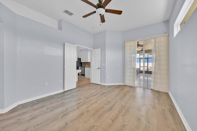 empty room with light wood-style floors, baseboards, visible vents, and ceiling fan