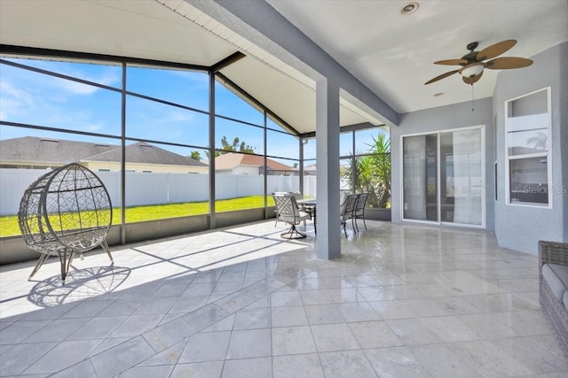 unfurnished sunroom featuring vaulted ceiling with beams and ceiling fan