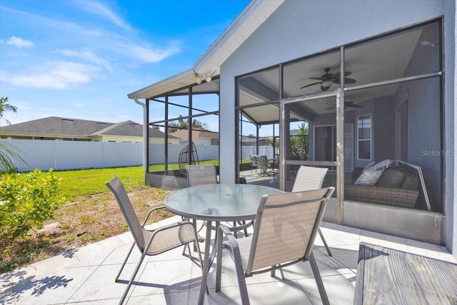 view of patio featuring ceiling fan, a fenced backyard, and a sunroom