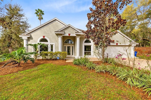 neoclassical home featuring a front yard and a garage