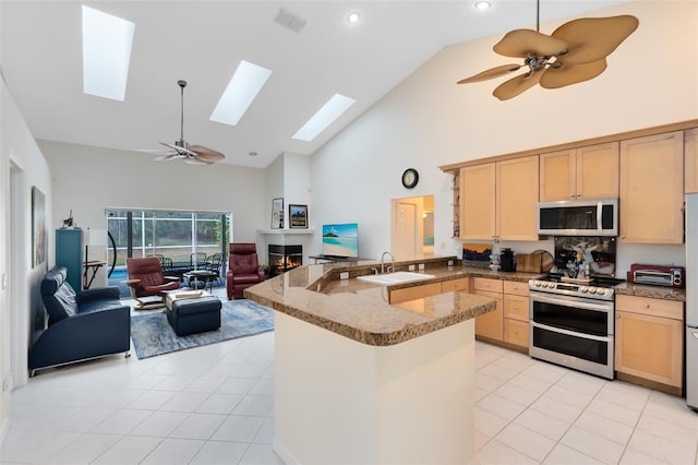 kitchen with sink, ceiling fan, light tile patterned floors, appliances with stainless steel finishes, and light brown cabinets