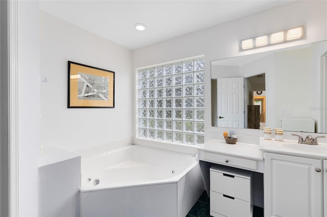bathroom with vanity, a wealth of natural light, and a tub to relax in
