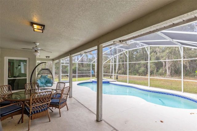 view of swimming pool with ceiling fan, glass enclosure, and a patio
