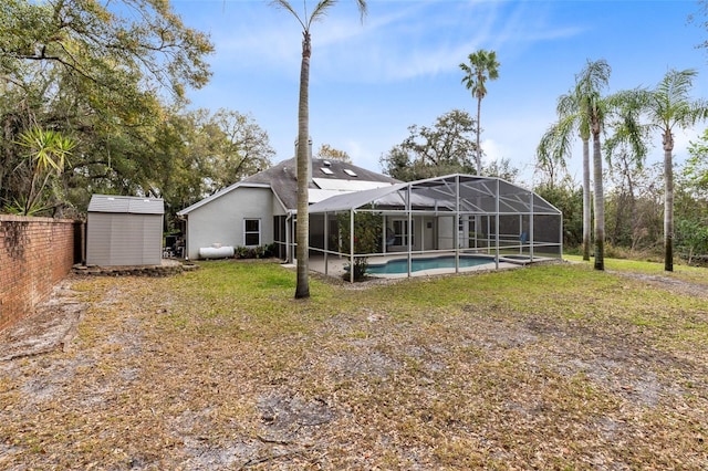 rear view of property featuring a yard, a lanai, and a storage shed