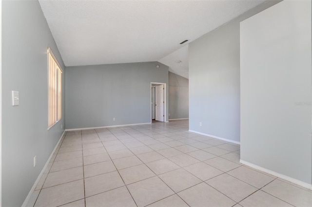 unfurnished room featuring visible vents, vaulted ceiling, baseboards, and light tile patterned floors