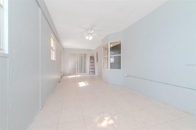 interior space with light tile patterned floors and ceiling fan