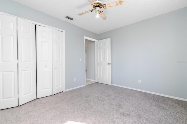 unfurnished bedroom with baseboards, visible vents, a closet, and light colored carpet