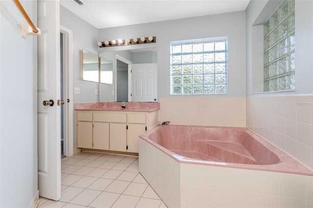 bathroom with tile patterned flooring, a garden tub, and vanity