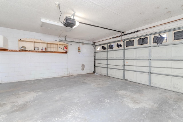 garage with concrete block wall and a garage door opener