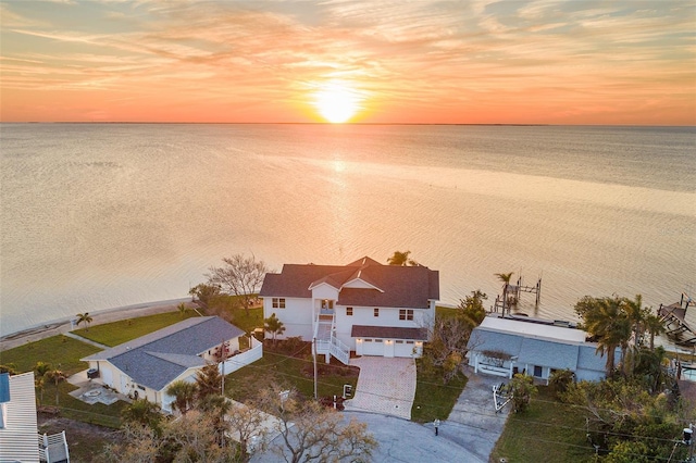 aerial view at dusk featuring a water view