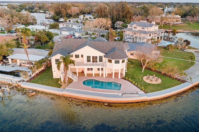 back of house featuring a residential view, a patio area, a water view, and stairs