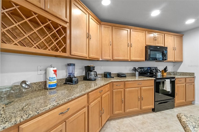 kitchen with light stone countertops, light tile patterned floors, and black appliances